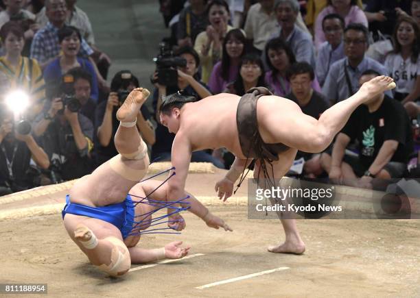Yokozuna Hakuho of Mongolia throws down komusubi Kotoshogiku on the opening day of the 15-day Nagoya Grand Sumo Tournament at Aichi Prefectural...