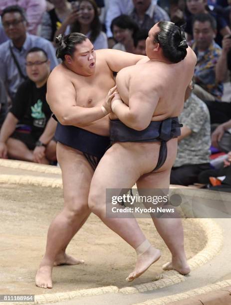 Yokozuna Kisenosato is forced out of the ring by sekiwake Mitakeumi on the opening day of the 15-day Nagoya Grand Sumo Tournament at Aichi...