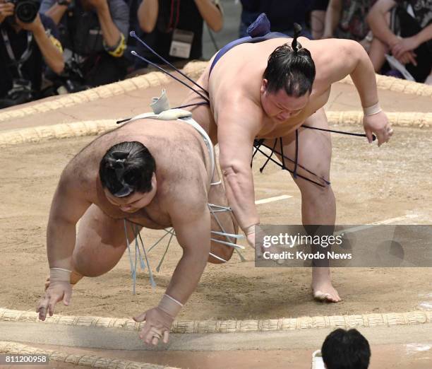 Takayasu , promoted to sumo's second-highest rank ozeki after the last tourney in May, is sent to the ground by No. 2 maegashira Hokutofuji on the...