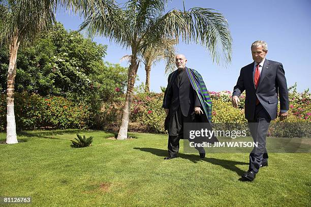 President George W. Bush walks with his Afghan counterpart Hamid Karzai after a bilateral meeting in the Egyptian Red Sea resort of Sharm El-Sheikh...