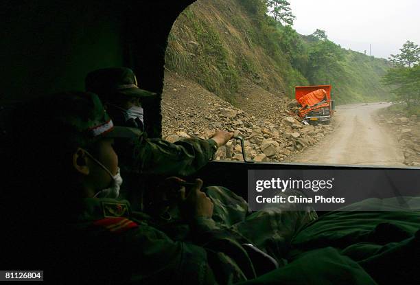 Wreckage of a van covered by a landslide triggered by the earthquake is seen on a road on May 16, 2008 iin the Hongbai Township, Shifang County,...