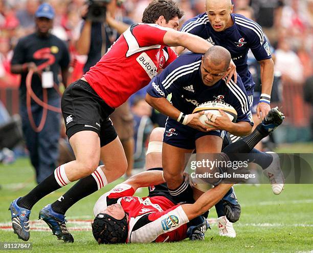 Wylie Human of the Stormers is tackled by Joe van Niekerk with Jaque Fourie in support for the Lions during the Super 14 match between Lions and...