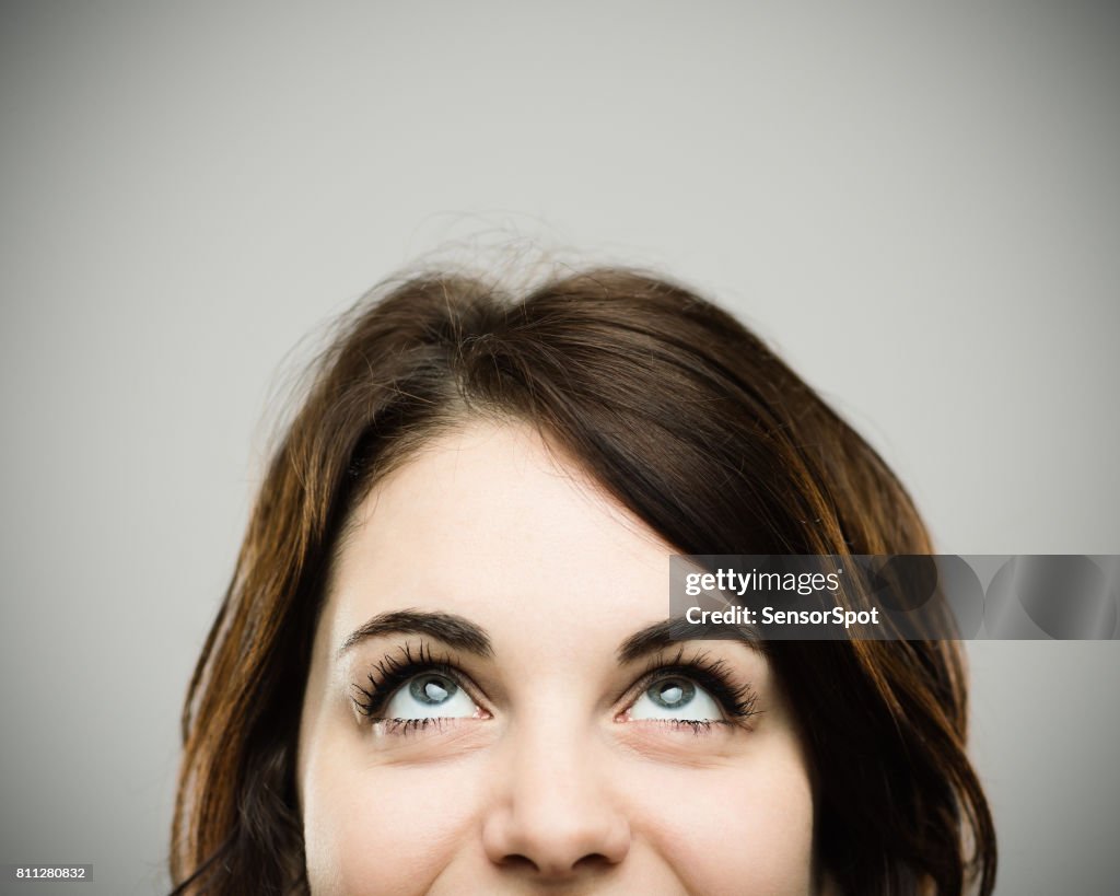 Real young woman looking up and smiling