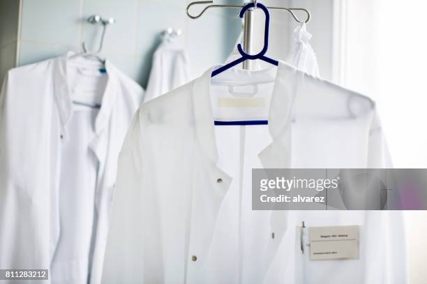 camice da laboratorio del medico sul gancio in laboratorio - casacca foto e immagini stock