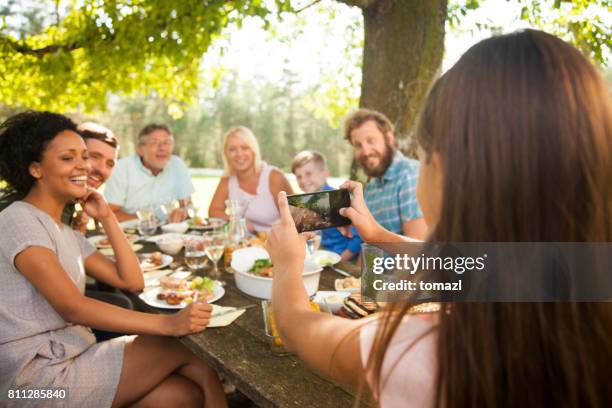 tochter, die unter einem gruppenfoto auf ein familientreffen - familientreffen stock-fotos und bilder