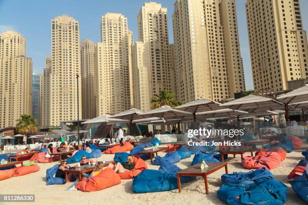 relaxing on beanbags at a beach cafe on the walk at jbr, dubai. - dubai jbr stock pictures, royalty-free photos & images