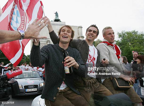 Andreas Ottl, Philipp Lahm and Christian Lell of Bayern Munich celebrate during a car convoy at Leopold Street during the Bundesliga match between FC...