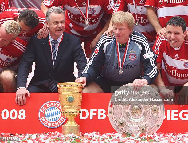 Goalkeeper Oliver Kahn and his head coach Ottmar Hitzfeld pose with the German Championship trophy and the DFB Cup trophy after the Bundesliga match...