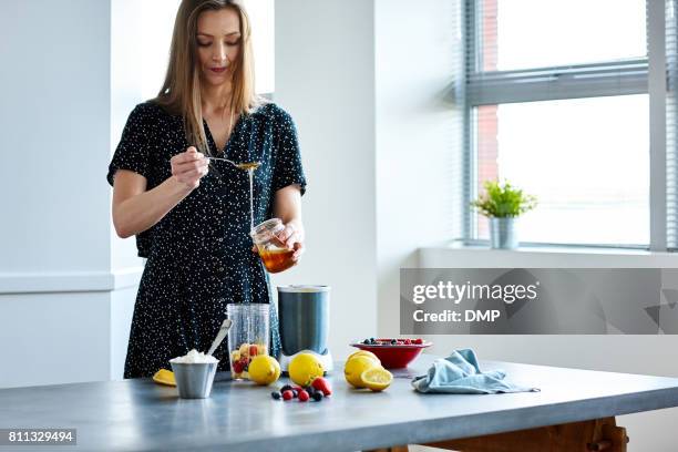 mujer preparando bebida tropical en casa - cocktail making fotografías e imágenes de stock