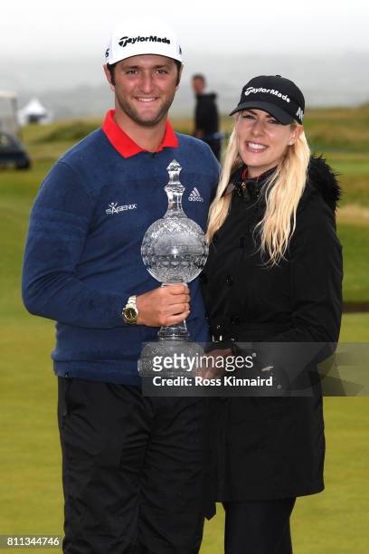 Jon Rahm of Spain poses with the trophy and girlfriend Kelley Cahill after his victory on the 18th hole during the final round of the Dubai Duty Free...