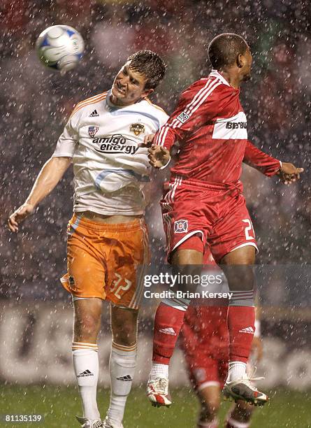 Bobby Boswell of the Houston Dynamo and Andy Herron of the Chicago Fire go up for a header during the second half at Toyota Park on May 17, 2008 in...