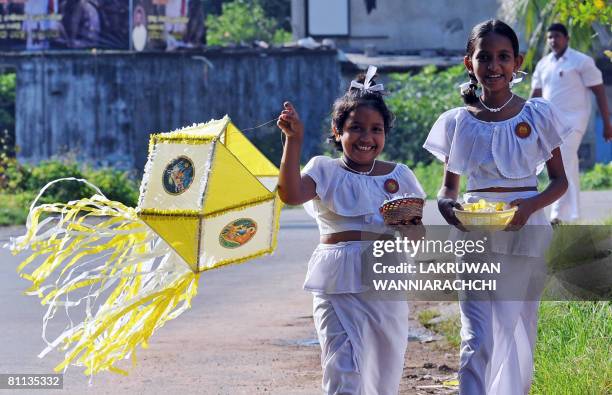 Sri Lankan children carry lanterns on their way to school on the eve of the Buddhist festival of Vesak, on May 18, 2008 in Colombo, as the...