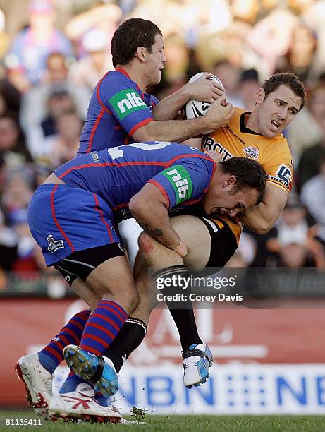 Dean Collis of the Tigers is tackled during the round 10 NRL match between the Newcastle Knights and the Wests Tigers at EnergyAustralia Stadium on...