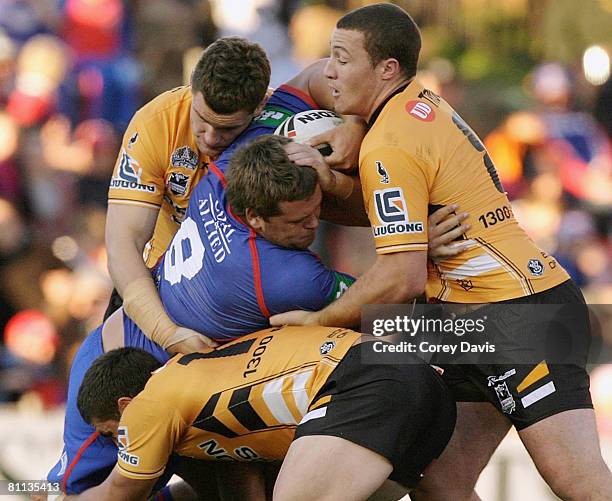 Danny Wicks of the Knights is tackled during the round 10 NRL match between the Newcastle Knights and the Wests Tigers at EnergyAustralia Stadium on...