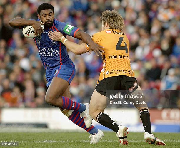 Wes Naiqama of the Knights is tackled by Chris Lawrence of the Tigers during the round 10 NRL match between the Newcastle Knights and the Wests...