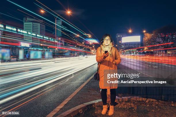 woman using smart phone in urban city - movimiento velocidad vida en la ciudad rastros de luz fotografías e imágenes de stock
