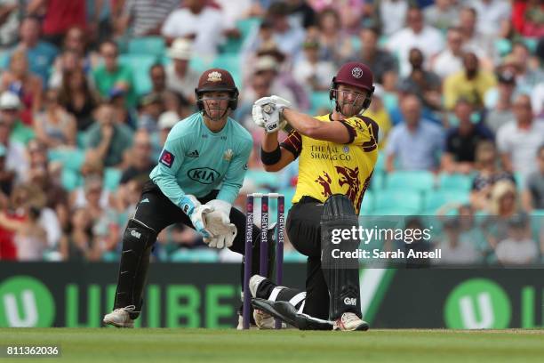 Corey Anderson of Somerset hits a boundary during his innings of 81 as Surrey wicket keeper Rory Burns looks on during the NatWest T20 Blast match at...