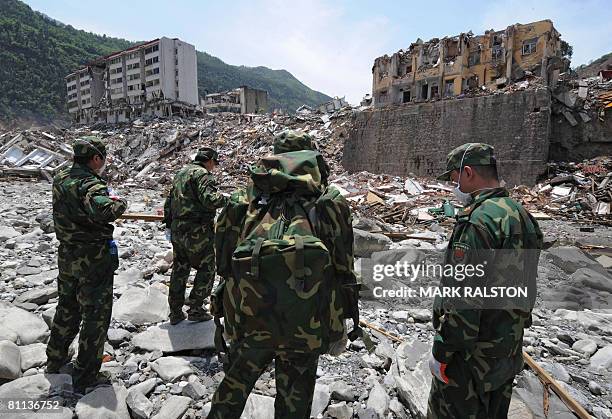 Chinese soldiers stand in a dry riverbed, blocked by a landslide further upriver caused by the earthquake in the town of Beichuan in Sichuan Province...