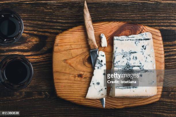 gorgonzola cheese on wooden cutting board - gorgonzola stockfoto's en -beelden