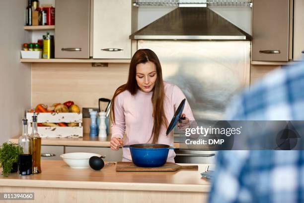 schöne reife frau, die kochen zu hause - casserole stock-fotos und bilder