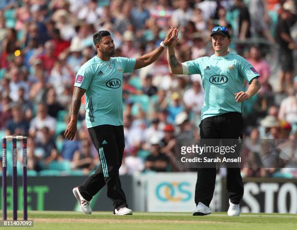 Ravi Rampaul of Surrey celebrates with teammate Jason Roy after taking the wicket of Somerset's Lewis Gregory during the NatWest T20 Blast match at...