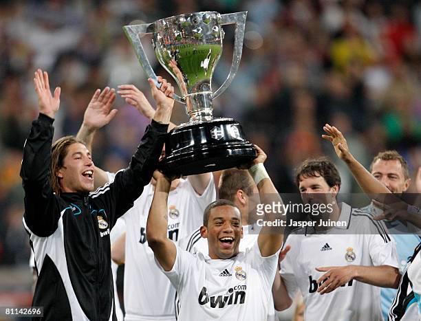Marcelo of Real Madrid holds aloft the La Liga trophy flanked by his teammates Sergio Ramos and Ruud van Nistelrooy at the end of the La Liga match...
