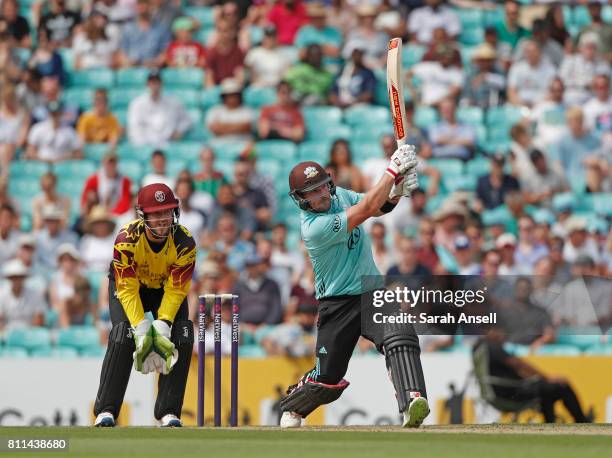 Aaron Finch of Surrey hits a six as Somerset wicket keeper Steven Davies looks on during the NatWest T20 Blast match at The Kia Oval on July 9, 2017...