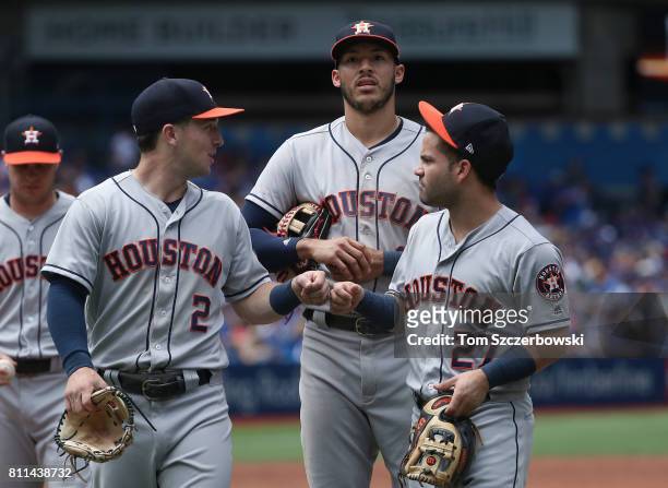 Alex Bregman of the Houston Astros celebrates with Carlos Correa and Jose Altuve after getting the last out of the third inning during MLB game...