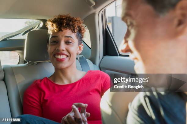 passenger driver interaction in rideshare taxi car miami usa - jamaican ethnicity stock pictures, royalty-free photos & images