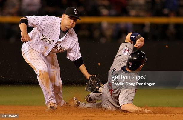 Brendan Harris of the Minnesota Twins slides under the tag of Clint Barmes of the Colorado Rockies as he steals second base in the ninth inning...