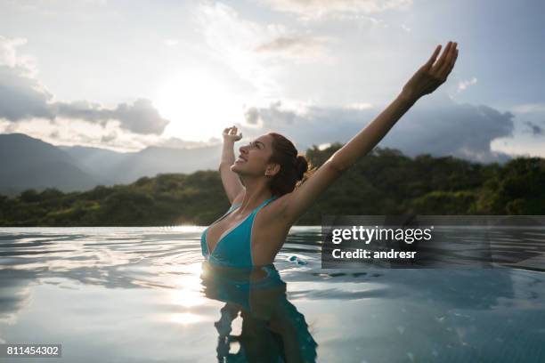 happy woman enjoying her holidays in the swimming pool - happy holidays around the world stock pictures, royalty-free photos & images