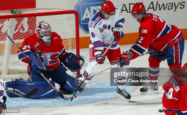 Matt Halischuk of the Kitchener Rangers tries to tip an incoming shot between Dustin Tokarski and Jared Cowen of the Spokane Chiefs in a Memorial Cup...