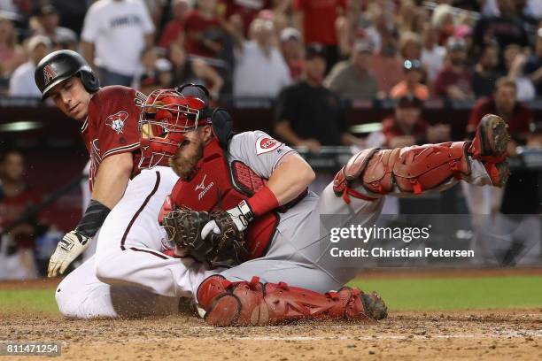 Paul Goldschmidt of the Arizona Diamondbacks is tagged out at home plate by catcher Tucker Barnhart of the Cincinnati Reds during the sixth inning of...