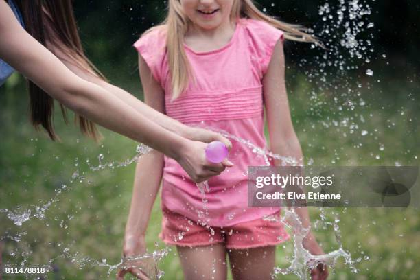 two girls playing with water bombs - exploded view real stock pictures, royalty-free photos & images