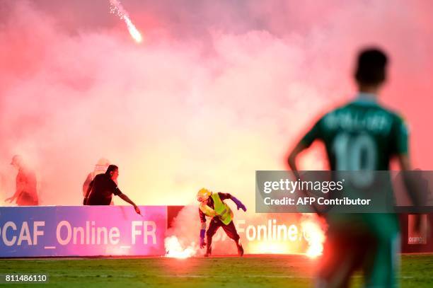 Egyptian civil defense extinguish flares during the football match between Zamalek and Al Ahly Tripoli during their African Champions League group...