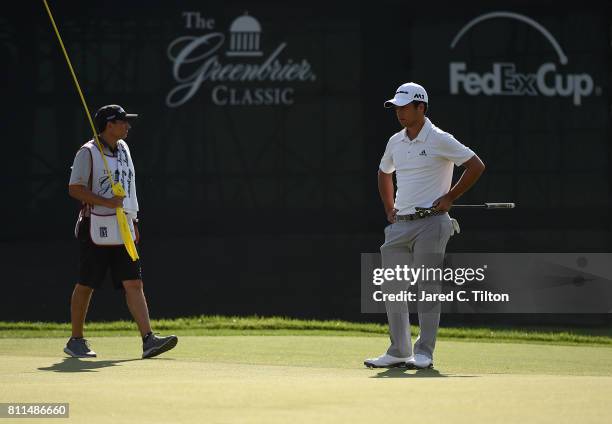 Xander Schauffele and his caddie wait on the 18th green during the final round of The Greenbrier Classic held at the Old White TPC on July 9, 2017 in...