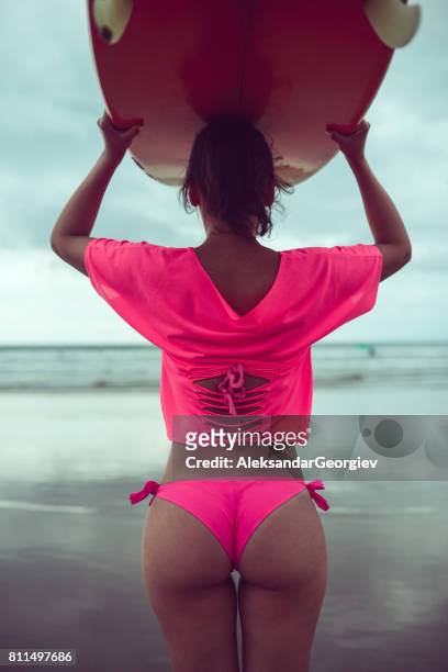 bella surfista femenina con tabla de surf en playa tropical al atardecer - tanga fotografías e imágenes de stock