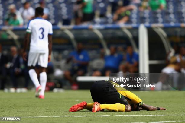 Alvas Powell of Jamaica hugs the ground after missing a shot on goal as Cuco Martina of Curacao walks off during the first half of a 2017 CONCACAF...