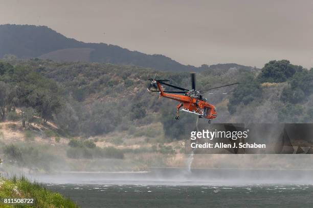 Fire-fighting helicopter draws water from Lake Cachuma while fighting the Whittier Fire in the Los Padres National Forest near Lake Cachuma, Santa...