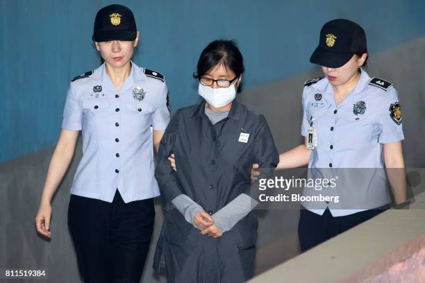 Choi Soon-sil, a long-time friend of South Korea's former President Park Geun-hye, center, is escorted by prison officers as she arrives at the Seoul...