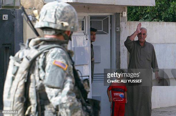 An Iraqi man waves to a US soldier from 3rd squadron 3rd armored cavalry during a joint patrol with Iraqi soldiers of the 2nd division in the...