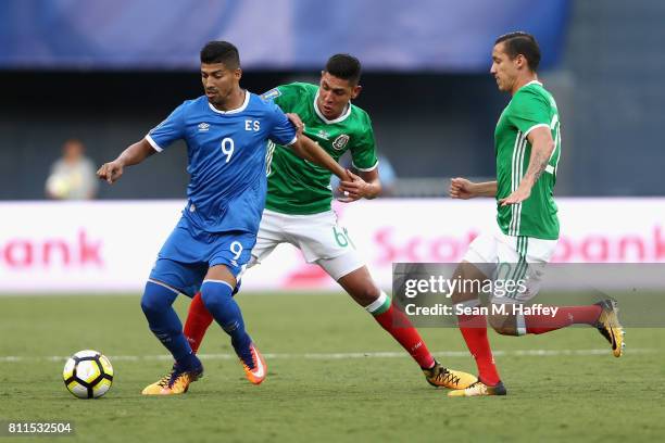 Nelson Bonilla of El Salvador dribbles past Edson Alvarez and Jesus Duenas of Mexico during the first half of a 2017 CONCACAF Gold Cup Group C match...