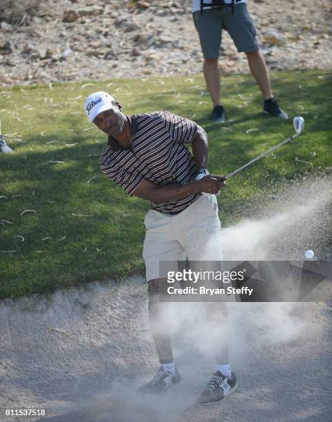 Broadcaster and former professional basketball player Eddie Johnson hits a sand bunker shot during the Coach Woodson Las Vegas Invitational at...