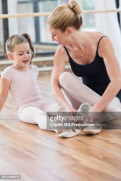 ballet instructor helps student with ballet shoes - leotard and tights stock pictures, royalty-free photos & images