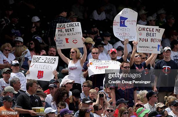 Minnesota Twins fans use signs to encourage television commentator Bert Blyleven to circle them on the telestrator as the Twins face the Colorado...