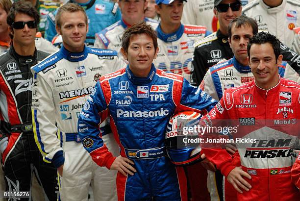 Indy 500 drivers Hideki Mutoh and Helio Castroneves pose with the rest of the field at the "Charging Bull" statue in Bowling Green Park during a...