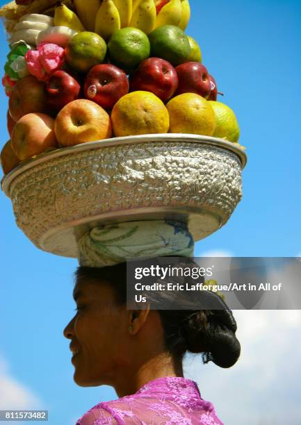 Woman carrying offerings on her head during a traditional hindu temple festival procession, Bali island, Canggu, Indonesia on July 15, 2005 in...