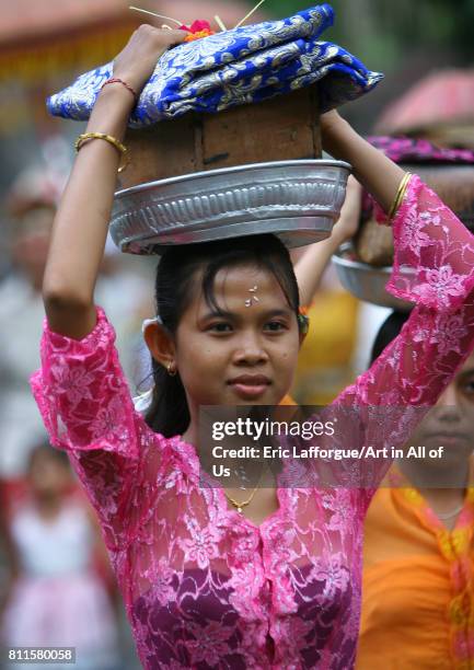 Woman carrying offerings on her head during a traditional hindu temple festival procession, Bali island, Canggu, Indonesia on July 13, 2005 in...