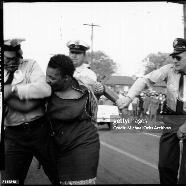 An African American woman bites a policeman during a protest against segregation organized by Reverend Dr. Martin Luther King Jr. And Reverend Fred...