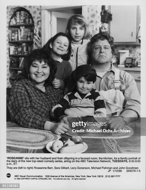 The cast of the tv sitcom 'Roseanne'. They are Roseanne Barr, Sara Gilbert, Lecy Goranson, Michael Fishman and John Goodman.